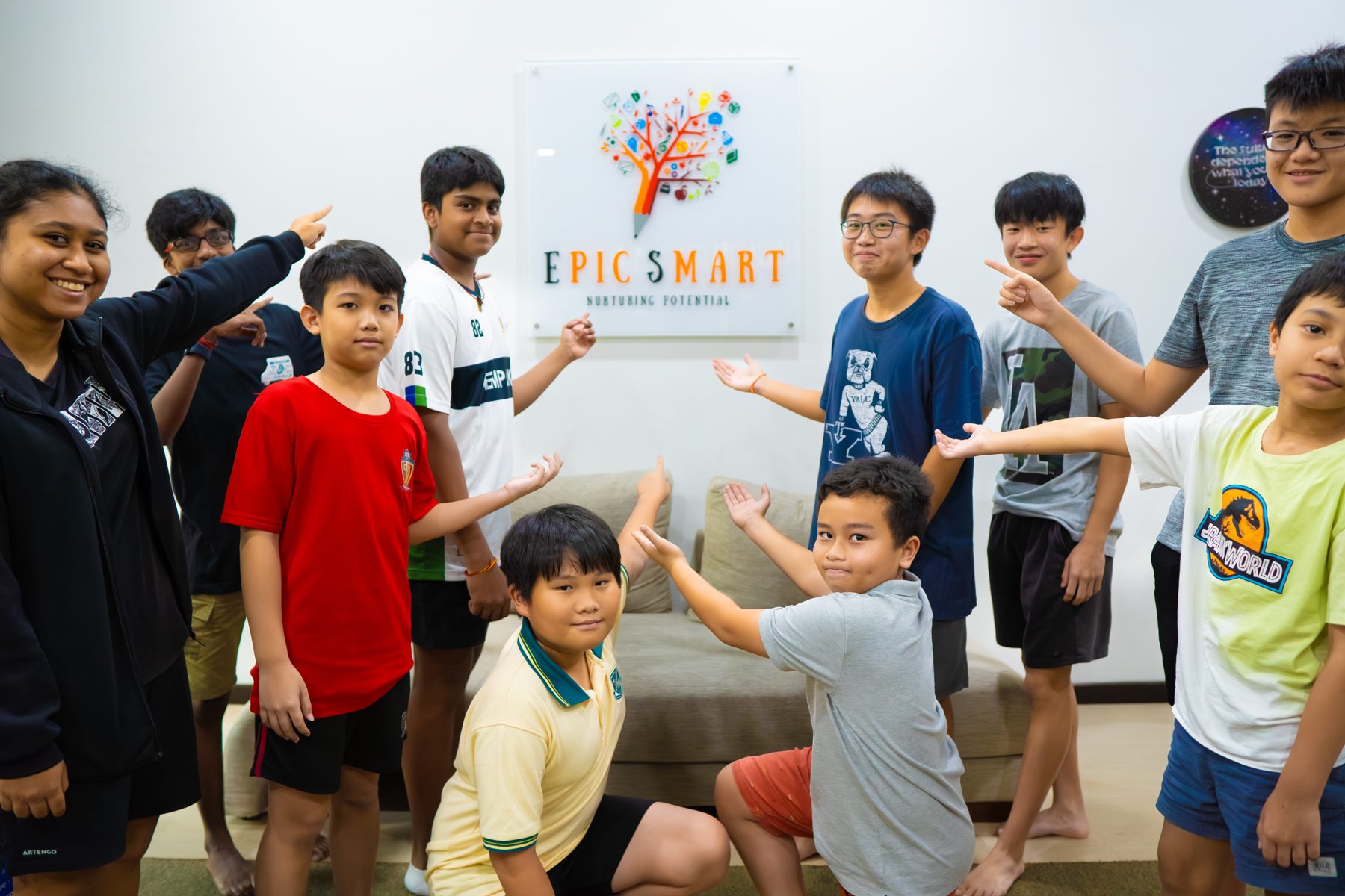 Students proudly pointing at the Epic Smart Academy logo